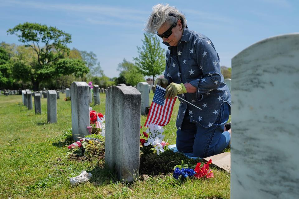 Diane Leclair installs flowers and American flags in front of her father Albert Charles Normandin's grave at Pine Grove Cemetery in New Bedford in preparation for Memorial Day. Mr. Normandin was a Marine during WWII and fought during the battle of Iwo Jima.