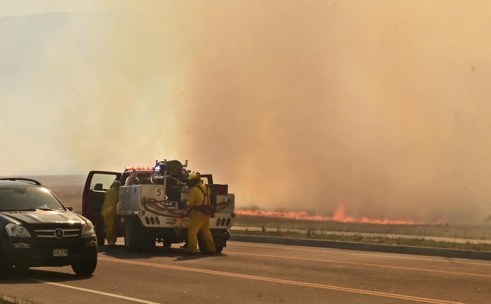 FILE - A firefighting crew arrives at the scene of a field on fire adjacent to the Amazon Distribution Center in Colorado Springs, Colo., on May 12, 2022. More than 5,000 firefighters are battling multiple wildland blazes in dry, windy weather across the Southwest. Evacuation orders remained in place Thursday, May 19, 2022, for residents near fires in Texas, Colorado and New Mexico. (Jerilee Bennett/The Gazette via AP, File)
