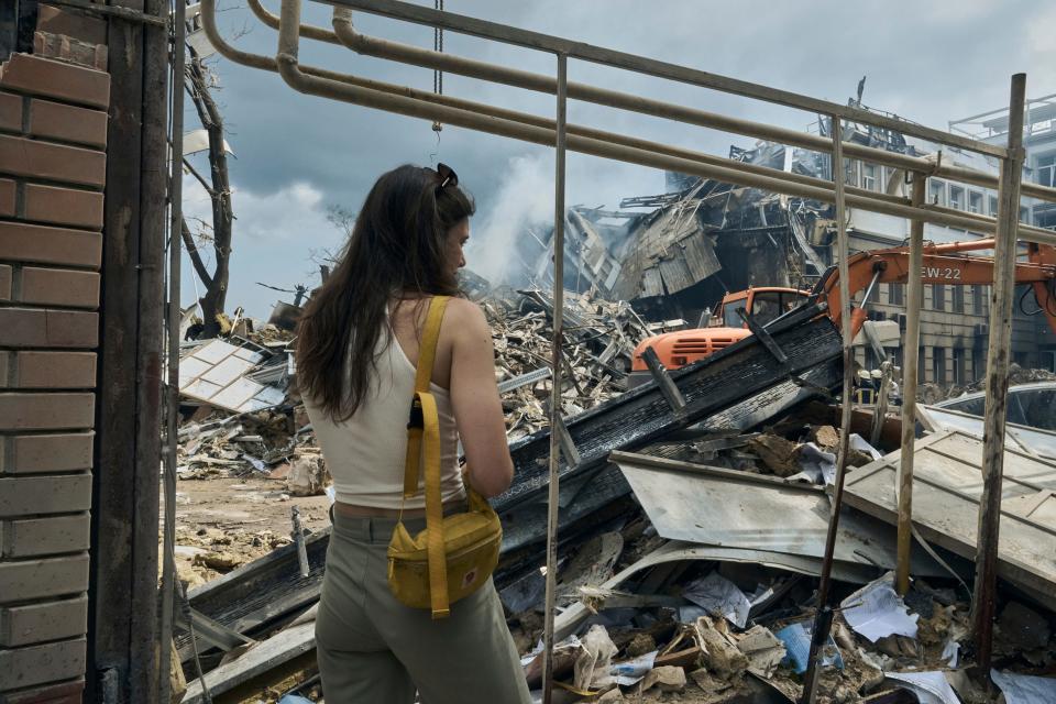 A woman watches as emergency service personnel work at the site of a destroyed building after a Russian attack in Odesa, Ukraine, on July 20, 2023.