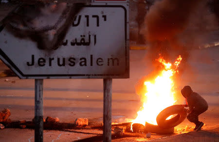 A Palestinian protester sets up a burning barricade near the West Bank city of Ramallah December 8, 2017. REUTERS/Goran Tomasevic