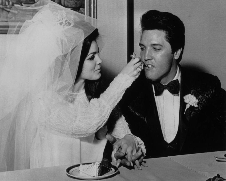 Elvis Presley (1935 - 1977) being fed a mouthful of wedding cake by his bride Priscilla Beaulieu at the Aladdin Hotel, Las Vegas. (Getty Images)