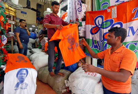 A customer (R) buys a T-shirt with an image of Prime Minister Narendra Modi at a shop at a market ahead of India's general election, in Kolkata, India, March 26, 2019. REUTERS/Rupak De Chowdhuri