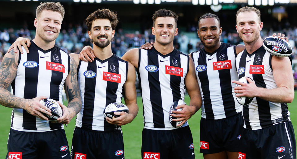 Jordan De Goey and Tom Mitchell with Collingwood teammates.