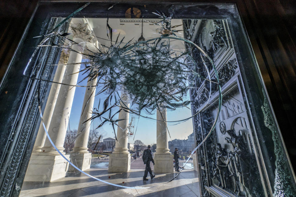 FILE - In this Jan. 12, 2021, file photo shattered glass from the attack on Congress by a violent pro-Trump mob is seen in doors leading to the Capitol Rotunda in Washington. Violent extremists motivated by political grievances and racial biases pose an “elevated threat” to the U.S. homeland, officials said Wednesday, March 17, in a unclassified intelligence report released more than two months after a violent mob of insurrectionists stormed the U.S. Capitol. (AP Photo/J. Scott Applewhite, File)