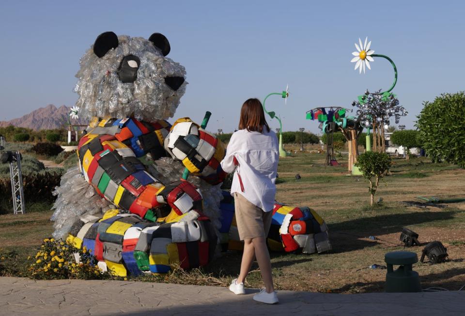 A visitor photographs a bear made of plastic waste in the Green Zone of the Cop27 climate conference (Getty)