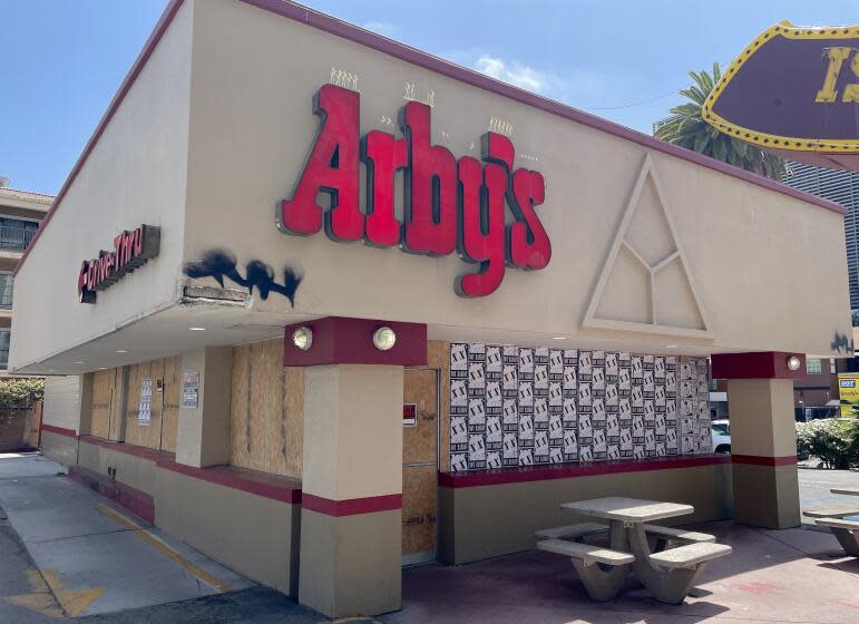 A photo outside Arby's Hollywood boarded with plywood and wheatpaste art.