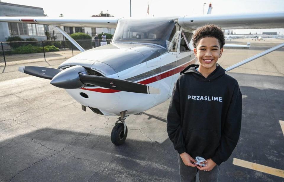 Sammy Taylor, 12, of Fresno stands next to the plane he’s been learning to fly in.