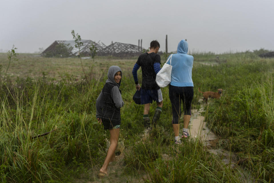 A family walks through the rain in search of shelter after their home flooded when Hurricane Ian hit in Pinar del Rio, Cuba, Tuesday, Sept. 27, 2022. Ian made landfall at 4:30 a.m. EDT Tuesday in Cuba’s Pinar del Rio province, where officials set up shelters, evacuated people, rushed in emergency personnel and took steps to protect crops in the nation’s main tobacco-growing region. (AP Photo/Ramon Espinosa)