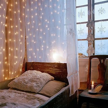 Cascade strings of fairy lights between layers of sheer curtains. 

Source