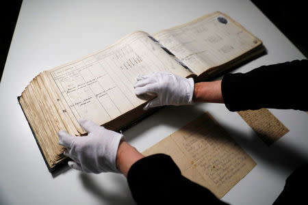 An album containing photographs and signatures of Jews from the Jewish community of Kavala in Greece, before most were killed in the Treblinka extermination camp, as well as other original documents are seen in the archive of the Yad Vashem World Holocaust Remembrance Center in Jerusalem, ahead of the Israeli annual Holocaust Remembrance Day, April 9, 2018. Picture taken April 9, 2018. REUTERS/Ronen Zvulun