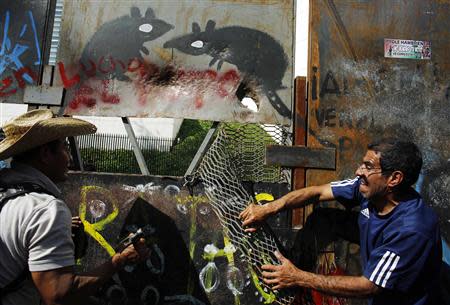 Protesters try to tear down a barricade surrounding the senate building in Mexico City December 9, 2013. REUTERS/Tomas Bravo