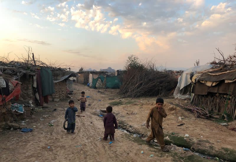 Children play outside their family's shelters at Afghan refugee camp in Islamabad