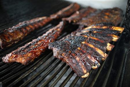 Beef and pork ribs lie on a grill at The Outdoor Grill in Culver City, Los Angeles, California April 10, 2014. REUTERS/Lucy Nicholson