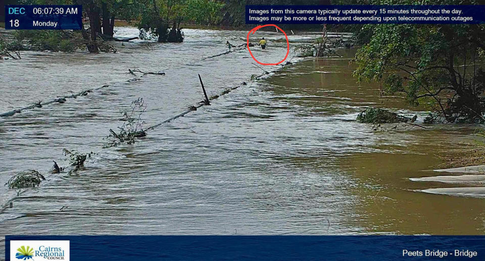 Council camera still showing man walking through floodwaters across a flooded bridge near Cairns. 
