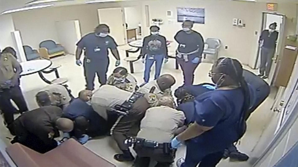 This video provided by Central State Hospital/Dinwiddie County, Va. shows a clip from surveillance camera of deputies and hospital employees on top of Irvo Otieno, who lies on the floor at Central State Hospital, on March 6, 2023 in Petersburg, Va. Footage obtained Tuesday, March 21, which has no audio, shows various members of sheriff's deputies and employees attempting to restrain a handcuffed and shackled Otieno for about 20 minutes after he's led into a room at the hospital, where he was going to be admitted. (Central State Hospital/Dinwiddie County, Va. Attorney via AP)