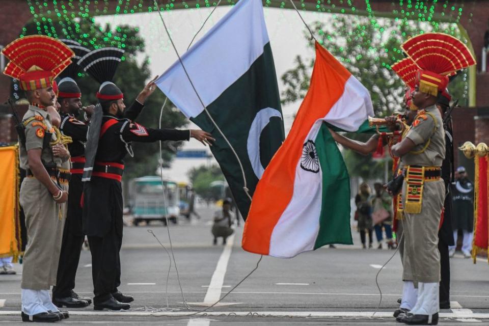 Tropas indias y pakistaníes celebran la ceremonia de bajada de banderas en el paso fronterizo de Wagah