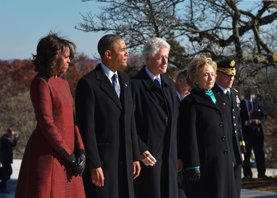 U.S. President Barack Obama(2nd-L), First Lady Michelle Obama(L) along with former president Bill Clinton(3rd-L) and former secretary of state Hillary Clinton(4th-L) take part in a wreath-laying ceremony in honour of the late 35th president of the U.S. John F. Kennedy at Kennedy's gravesite in Arlington National Cemetery on November 20, 2013 in Arlington, Virginia. (Photo credit should read MANDEL NGAN/AFP/Getty Images)