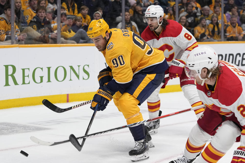 Nashville Predators center Ryan O'Reilly (90) races to the puck past Calgary Flames defenseman Chris Tanev (8) and center Blake Coleman, right, during the second period of an NHL hockey game Wednesday, Nov. 22, 2023, in Nashville, Tenn. (AP Photo/George Walker IV)