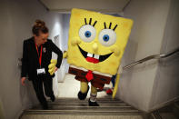 A Sponge Bob Square Pants character is helped up a flight of stairs during the 2013 London Toy Fair at Olympia Exhibition Centre on January 22, 2013 in London, England. (Photo by Dan Kitwood/Getty Images)