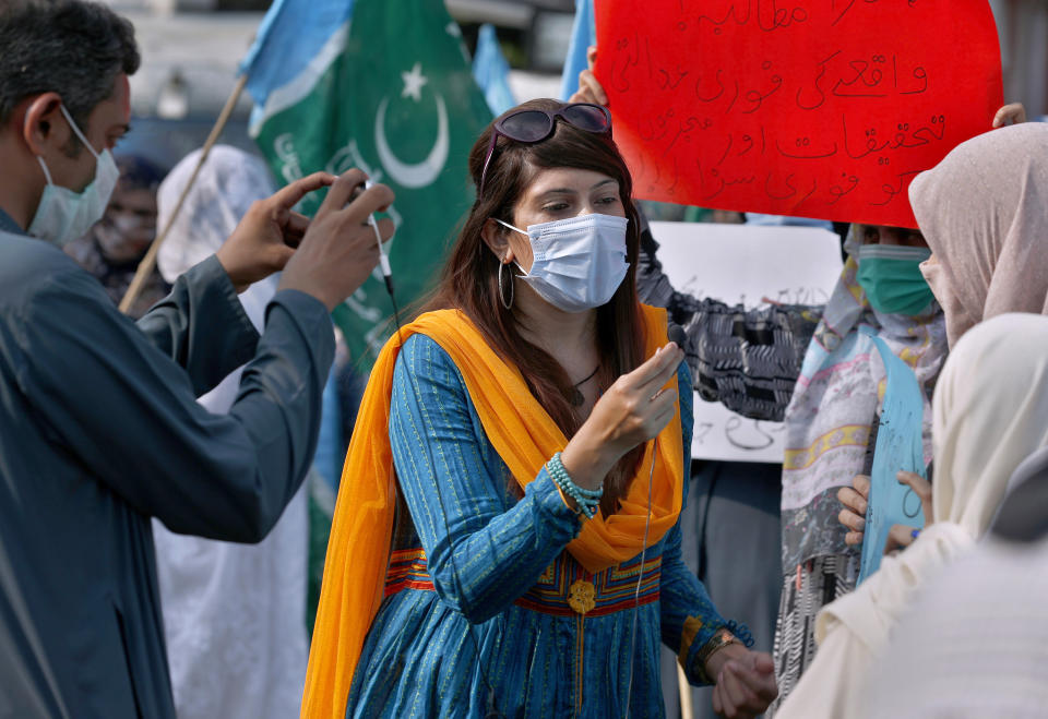 In this Friday, Sept. 11, 2020 photo, Mona Khan, a freelance female journalist, interviews during a rally, in Islamabad, Pakistan. Social media attacks against Pakistan's women journalists have been vile and vicious, some threatening rape, others even threatening death and the culprits are most often allied to the ruling party, even prompting the Committee to Protect Journalists to issue a statement on Friday, Sept. 18, condemning the relentless attacks. (AP Photo/Anjum Naveed)