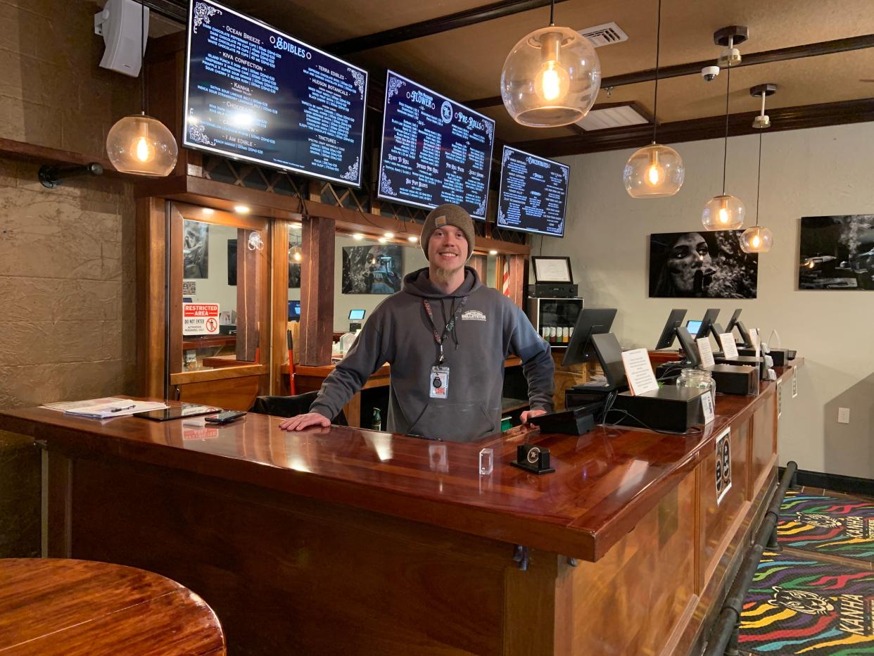 Ben Hagemeyer, a manager at Toy Town Health Care dispensary, stands behind the shop's speakeasy-style bar.