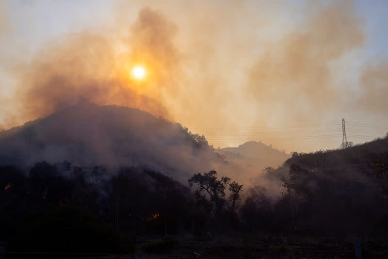 The Bond Fire wildfire continues to burn next to electrical power lines near Modjeska Canyon, California