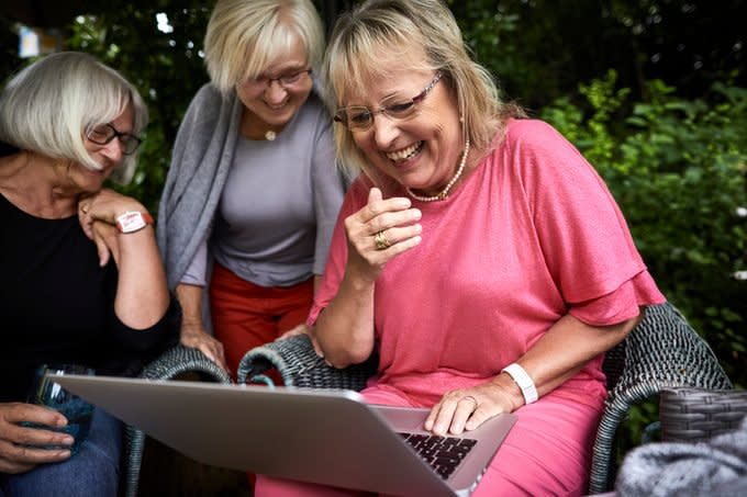 Happy senior women using laptop in garden