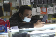 A smartphone seller wearing a face mask as a precaution against coronavirus outbreak waits for customers at a stall of a shopping mall in Jakarta, Indonesia, Monday, Jan. 4, 2021. Indonesia has reported more cases of the virus than any other countries in Southeast Asia and second in Asia only to India. (AP Photo/Tatan Syuflana)