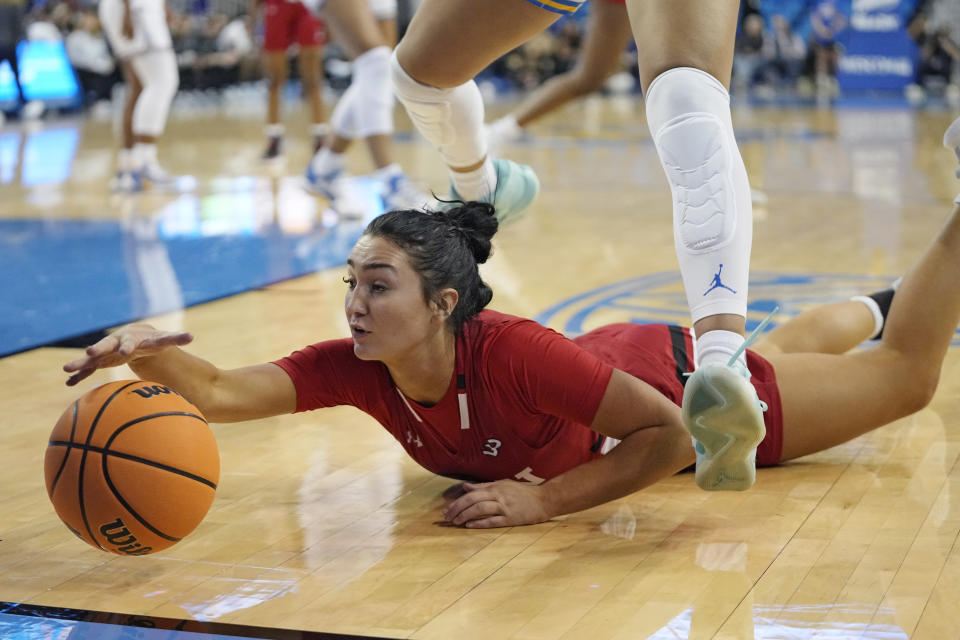 Cal State Northridge guard Rachel Harvey, left, reaches for a loose ball as UCLA guard Kiki Rice jumps over her during the second half of an NCAA college basketball game Thursday, Dec. 7, 2023, in Los Angeles. (AP Photo/Mark J. Terrill)