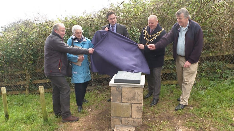 People unveiling the memorial