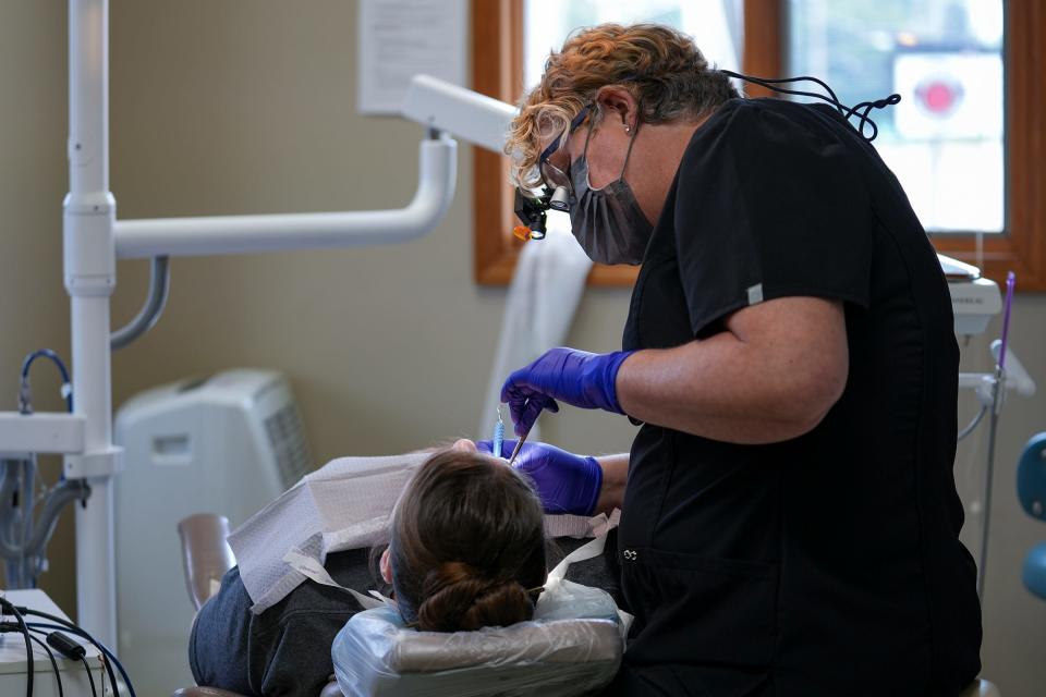 Dental hygienist Joyce Mopps cleans Jessica Brock's teeth Monday, August 21, 2023, at West Main Family Dental in Richmond, Ind. Brock found the office for her and her son after a difficult search for a practice that accepts Medicaid insurance.