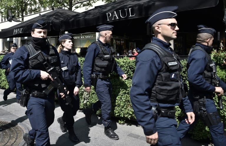 Police officers patrol on the Champs Elysees in Paris on April 21, 2017, a day after the attack that left one police officer dead and another one wounded