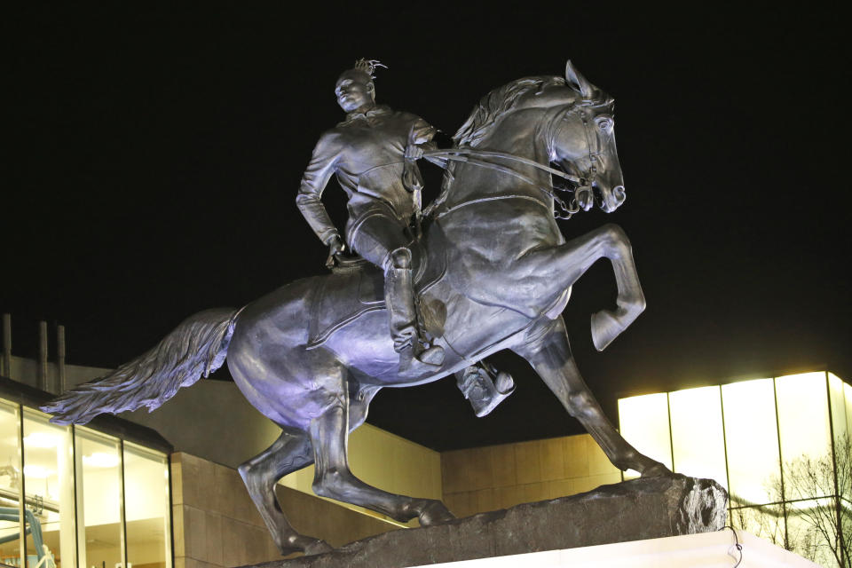 The statue titled Rumor's of War by artist Kehinde Wiley gets fully unveiled after the tarp covering the statue got stuck for a while at the Virginia Museum of Fine Arts in Richmond, Va., Tuesday, Dec. 10, 2019. The monumental bronze sculpture of a young black man astride a galloping horse was unveiled Tuesday, set to be permanently installed in Virginia's capital city, not far from the Confederate monument it mimics. (AP Photo/Steve Helber)