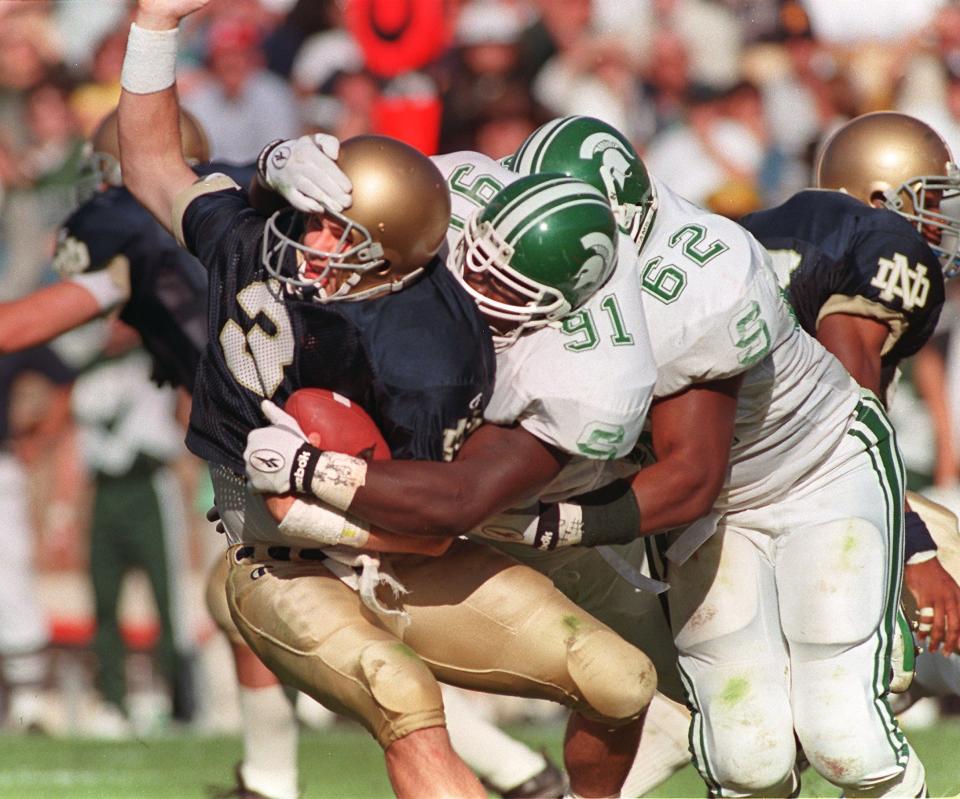 MSU defenders Robaire Smith (91) and Robert Newkirk (62) sack Notre Dame quarterback Ron Powlus on Sat. 9/20/97.