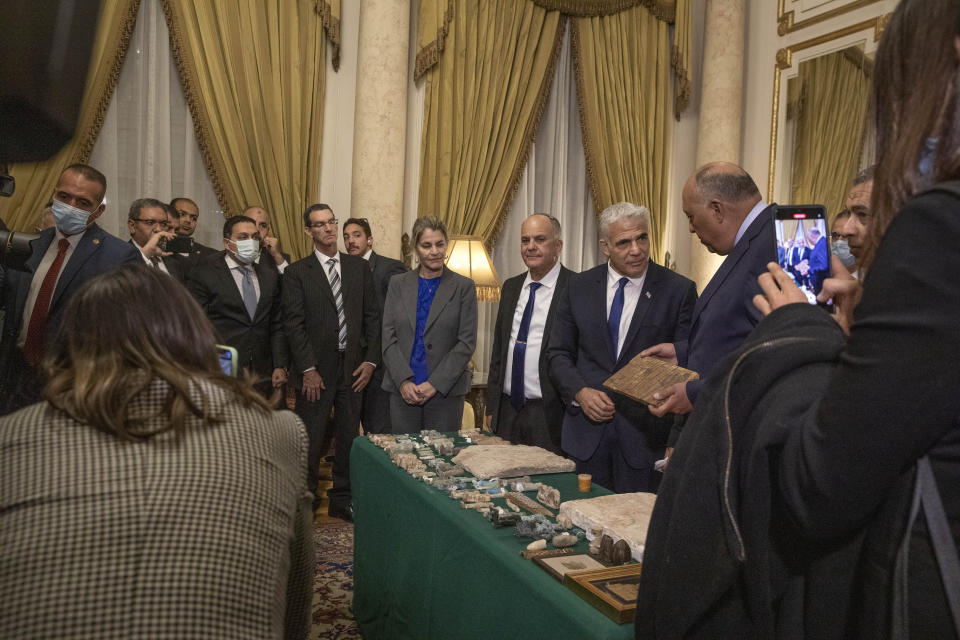 Israeli Foreign Minister Yair Lapid, presents Egyptian Foreign Minister Sameh Shoukry with stolen Egyptian artifacts that were smuggled to Israel and returned back to Egypt, at Tahrir Palace in Cairo, Egypt, Thursday, Dec. 9, 2021. (AP Photo/Nariman El-Mofty)