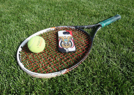 A tennis racket and a mobile phone with emblem of Yemen are seen during a match in the Asia under 14 Championship tournament in Doha, Qatar, March 6, 2017. Picture taken March 6, 2017. REUTERS/Naseem Zeitoon