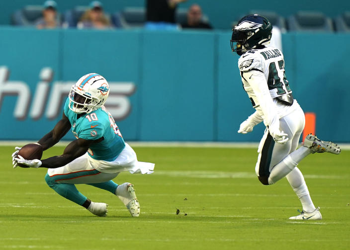 Miami Dolphins wide receiver Tyreek Hill (10) grabs a pass as Philadelphia Eagles safety K'Von Wallace (42) is late with the tag during the first half of a NFL preseason football game, Saturday, Aug. 27, 2022, in Miami Gardens, Fla. (AP Photo/Lynne Sladky)