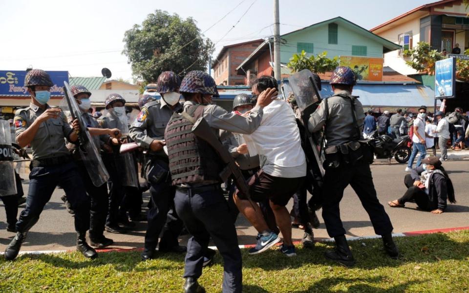 A demonstrator is detained by police officers during a protest against the military coup in Mawlamyine - THAN LWIN TIMES/via REUTERS
