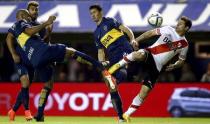 River Plate's Rodrigo Mora (R) is challenged by Boca Juniors' Guillermo Burdisso (2nd R), Daniel Diaz and Gino Peruzzi (L, back) during their Argentine First Division soccer match in Buenos Aires May 3, 2015. REUTERS/Marcos Brindicci
