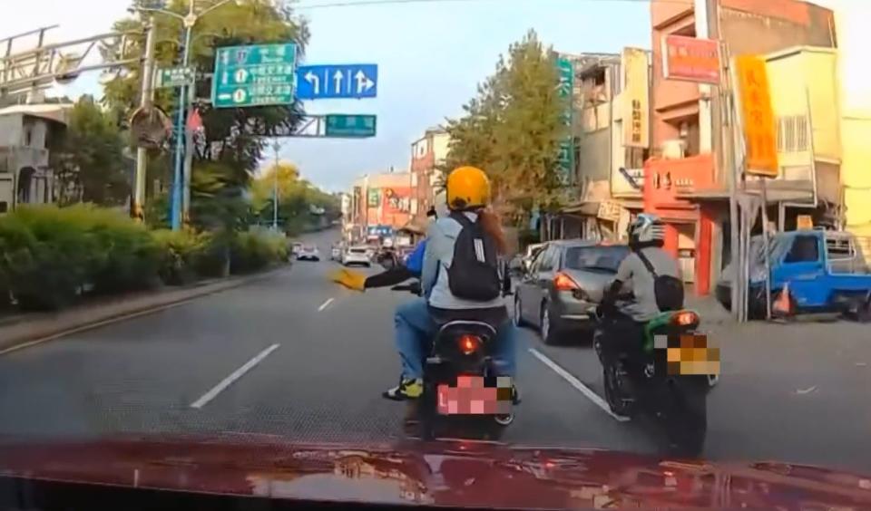 機車騎士單手騎車，用另外一隻手向駕駛比手勢。（圖／東森新聞）