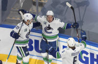 Vancouver Canucks' Bo Horvat (53), Troy Stecher (51) and Brock Boeser (6) celebrate a goal against the St. Louis Blues during the third period in Game 1 of an NHL hockey Stanley Cup first-round playoff series, Wednesday, Aug. 12, 2020, in Edmonton, Alberta. (Jason Franson/The Canadian Press via AP)