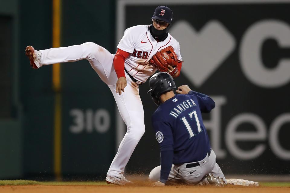 Seattle Mariners' Mitch Haniger (17) is out at second base as Boston Red Sox's Enrique Hernandez turns the double play on Ty France at first during the eighth inning of a baseball game Thursday, April 22, 2021, in Boston. (AP Photo/Michael Dwyer)