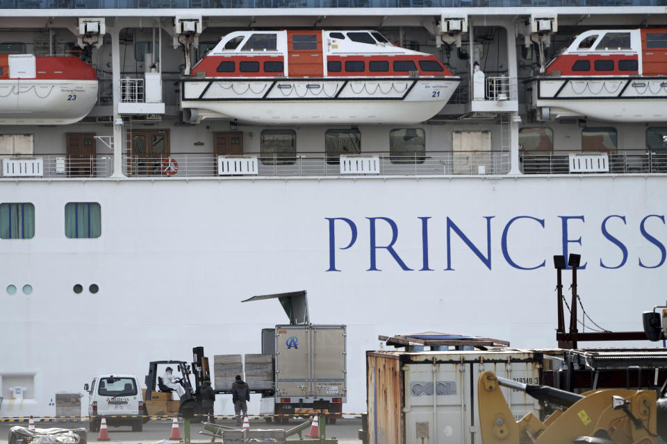 Officials and staffs unload supplies for the cruise ship Diamond Princess anchored at the Yokohama Port in Yokohama, near Tokyo Friday, Feb. 7, 2020. Japan on Friday reported 41 new cases of a virus on a cruise ship that's been quarantined in Yokohama harbor while the death toll in mainland China rose to 636, including a doctor who got in trouble with authorities in the communist country for sounding an early warning about the disease threat. (AP Photo/Eugene Hoshiko)