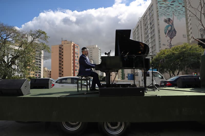 Pianist Rodrigo Cunha serenades from an open truck, in Sao Paulo