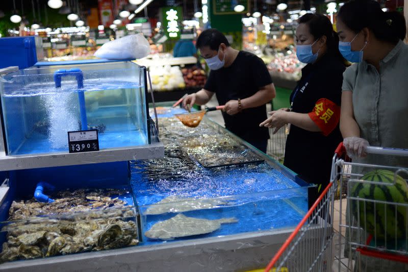 Customers wearing face masks shop live seafood at a Carrefour supermarket, following new cases of coronavirus disease (COVID-19) infections in Beijing