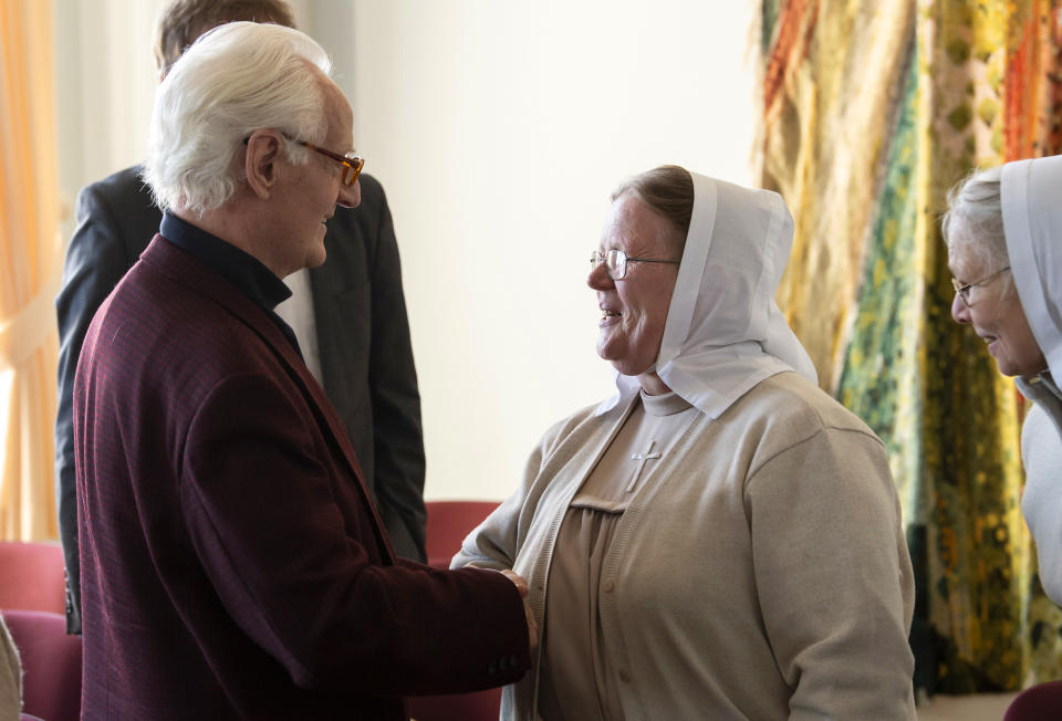 Plaintiff Michael Duellmann shakes hands with a sister prior to a trial at the Higher Regional Court in Naumburg, Germany, Tuesday, Jan. 21, 2020. The city of Wittenberg contains a Judensau (Jew-Pig) on the facade of the Stadtkirche (Town Church). The court will consider a Jewish man's bid to force the removal of an ugly remnant of centuries of anti-Semitism from a church where Martin Luther once preached. (AP Photo/Jens Meyer)