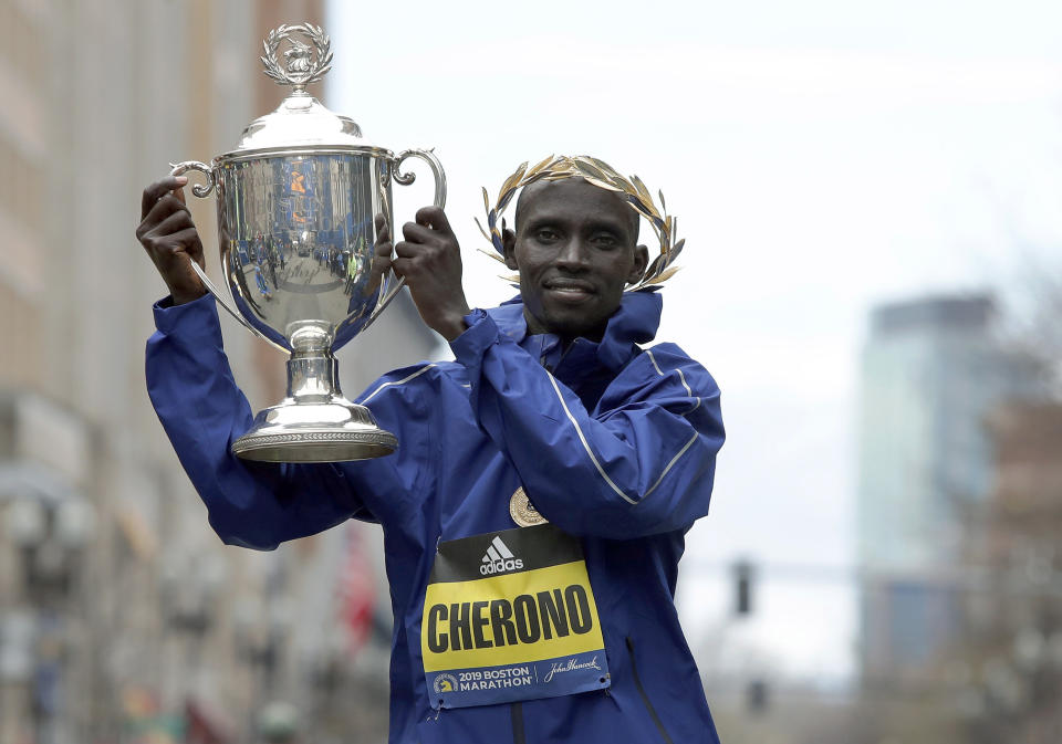 FILE - Lawrence Cherono, of Kenya, holds the trophy after winning the 123rd Boston Marathon, on Monday, April 15, 2019, in Boston. Cherono, a Kenyan runner who won the Boston and Chicago marathons has been banned for seven years for doping and trying to use fake documents to explain his failed drug test, the Athletics Integrity Unit said Wednesday July 10, 2024. (AP Photo/Winslow Townson, File)