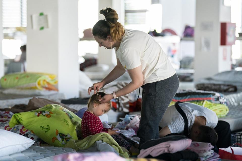 Ukrainian refugee Elena Sidorova brushes her daughter Zlata’s hair (Kirsty O’Connor/PA) (PA Wire)