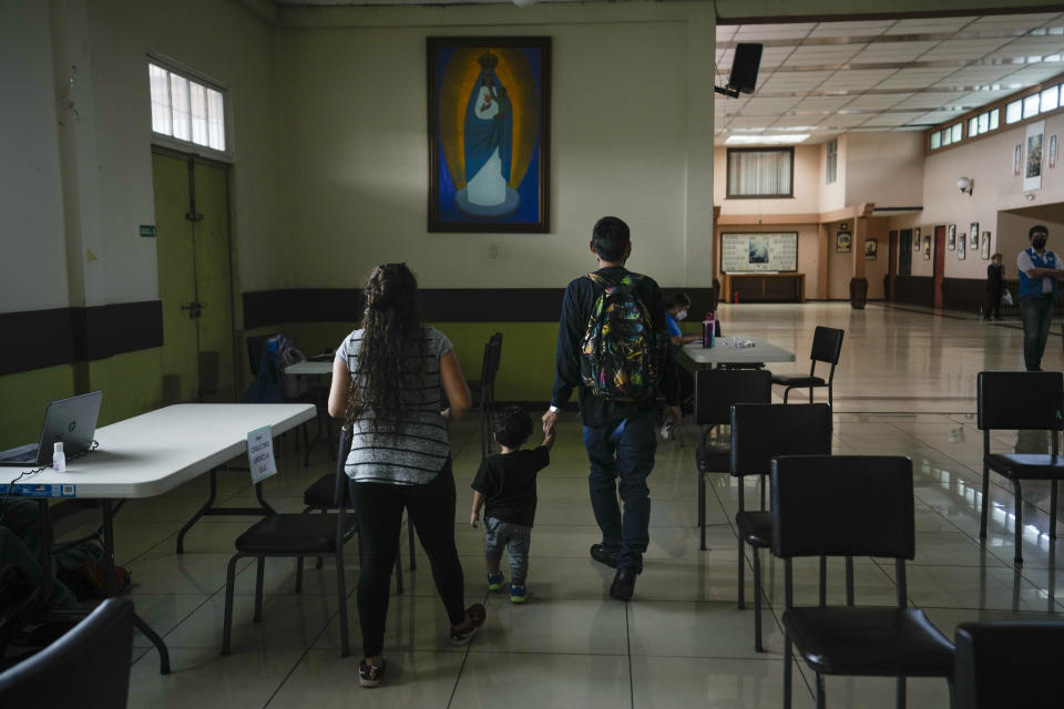 A Nicaraguan family arrives to a Catholic church where the United Nations High Commissioner for Refugees (UNHCR) has set up a field office to assist people applying for asylum in San Jose, Costa Rica, Monday, Aug. 29, 2022. A painting hangs of Cuban's "Nuestra Señora de la Caridad del Cobre" or, Our Lady of Charity. Nicaraguans have been seeking asylum in Costa Rica at the highest levels since Nicaragua’s political crisis exploded in April 2018. (AP Photo/Moises Castillo)