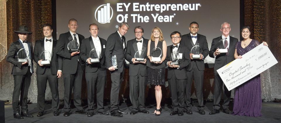 jeff green, CEO of the trade desk, fourth from left, wearing a black suit, holding an award, next to 10 other people